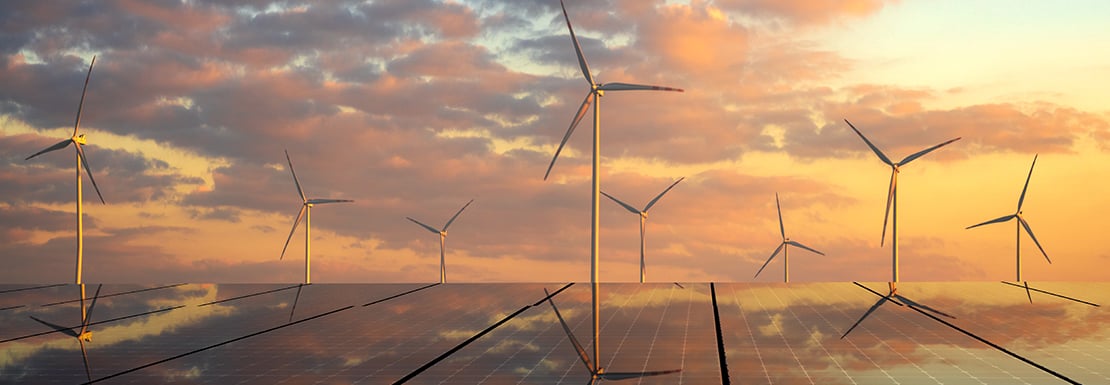 solar panels and wind turbines in sunset