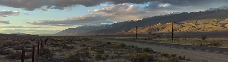 Poles and distribution lines along a round with mountains in the background